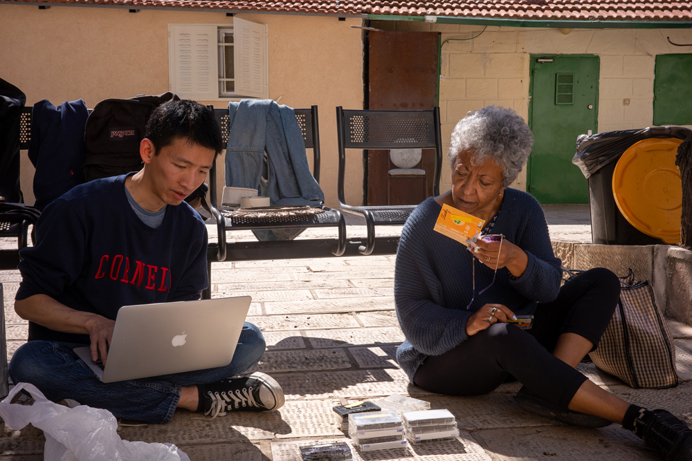 Thomas Feng, left, a Ph.D. candidate in performance practice, and Hanna Kebbede, the niece of Emahoy Tsege-Mariam Gebru who established the foundation that holds Emahoy’s archive, go through newly discovered cassette recordings by Emahoy at the courtyard of the Debre Genet Ethiopian Orthodox church in Jerusalem. The cassettes, along with manuscripts and recording equipment, were found in Emahoy’s room after her death. Photo by Cyrus Moussavi.