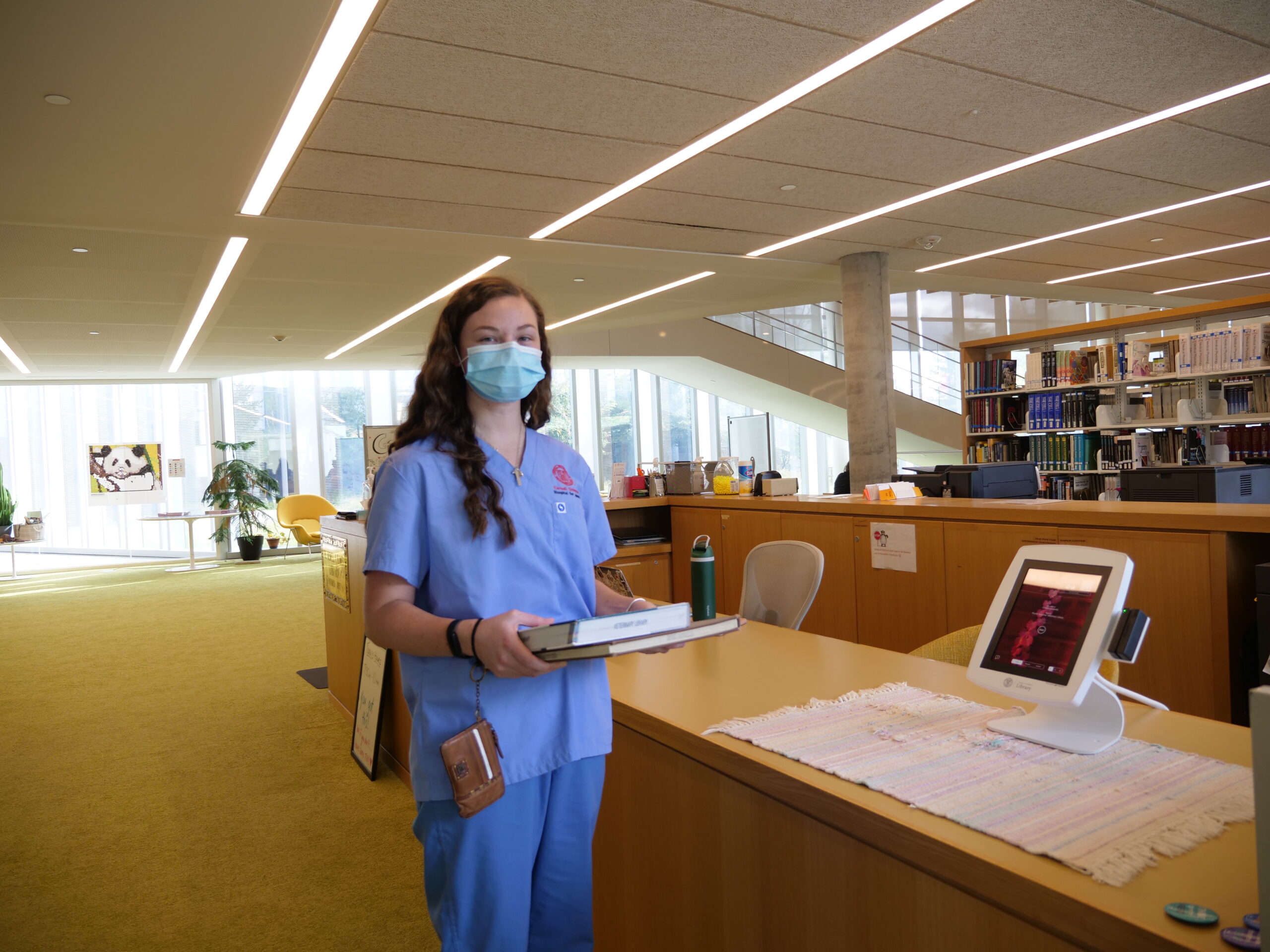 A veterinary student tries out the self-checkout kiosk at the Flower-Sprecher Veterinary Library.