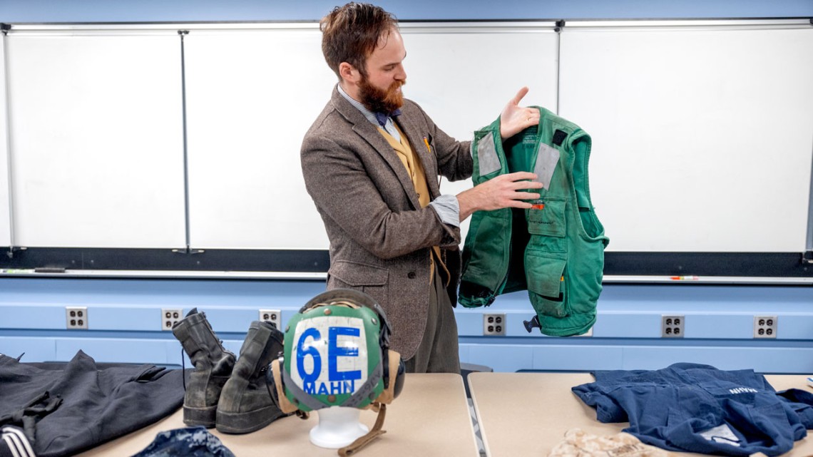 A student holding military veteran memorabilia