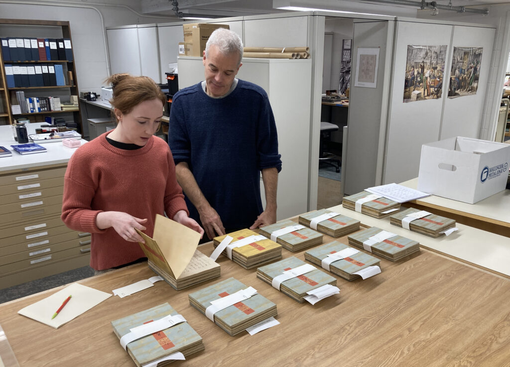 Library staff looking over manuscripts of the Tale of Genji in the Cornell University Library Conservation Lab.