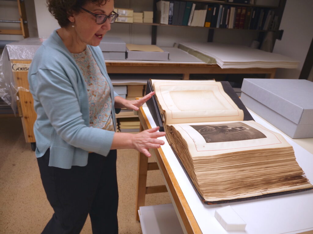 Conservator Michele Hamill opening a book of photographs