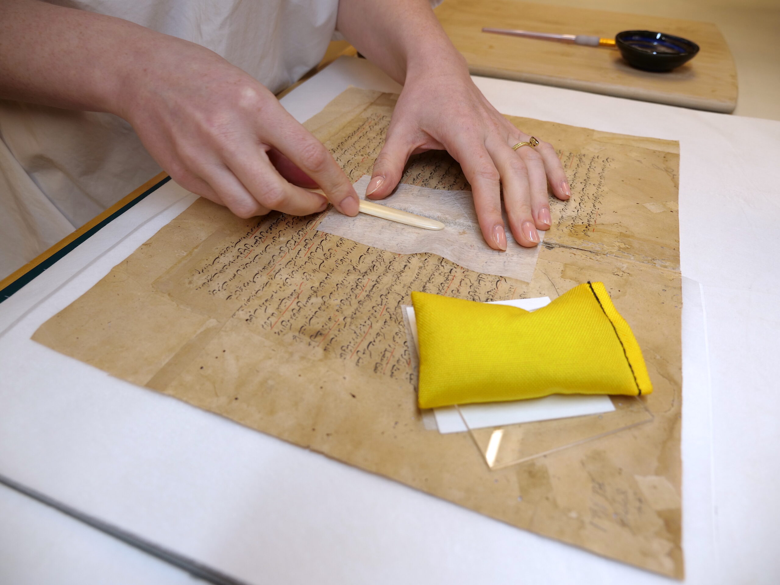 Trina Parks-Matthews performs stabilization treatments on a manuscript copy of the Tashrīh-i Manṣūrī, a Persian book of medical illustrations from 1661.